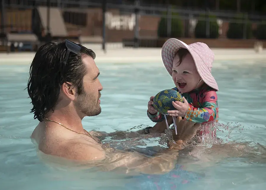 man holds daughter in pool
