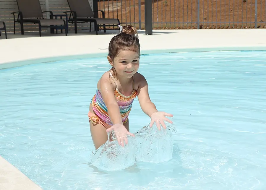 young girl splashing in pool