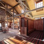 Forest Creek Golf Club clubhouse interior with exposed beams, stone fireplace, and wood lockers in Pinehurst, NC.